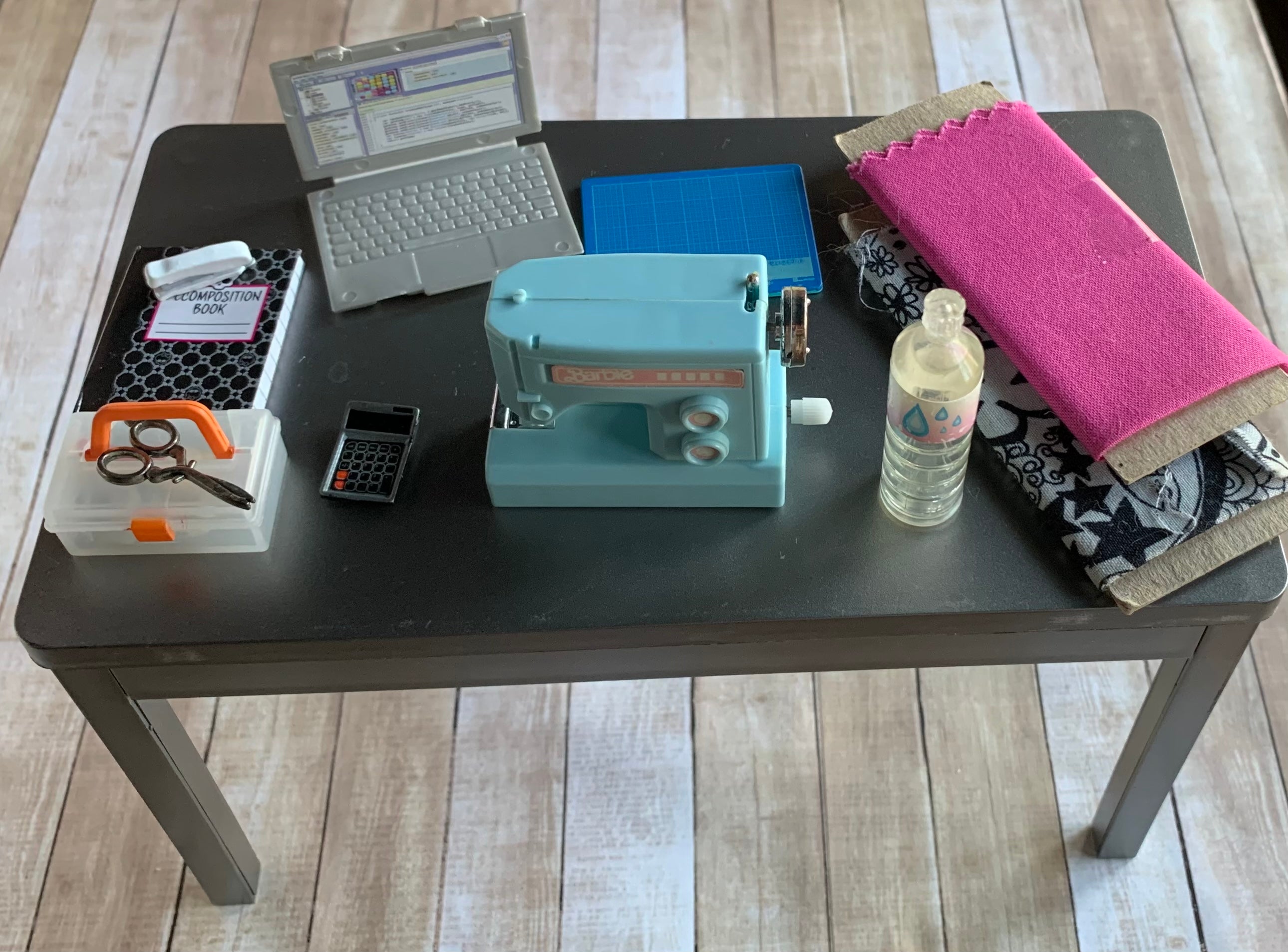 Miniature worktable filled with sewing and crafting supplies.